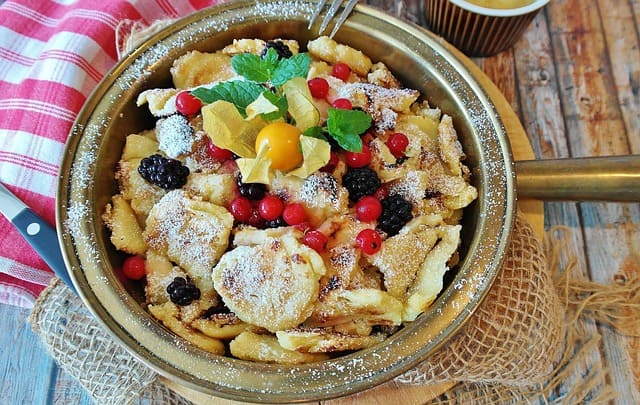 a bowl of food with berries Kaiserschmarrn